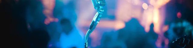 Microphone sur une scène avec des lumières de concert en arrière-plan.