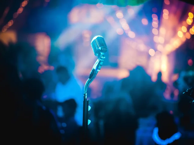 Microphone sur une scène avec des lumières de concert en arrière-plan.