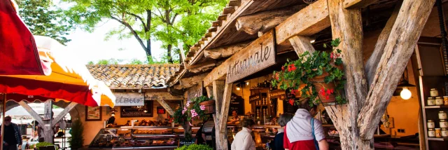 Scène de marché d’inspiration médiévale à La Flotte avec des stands en bois.