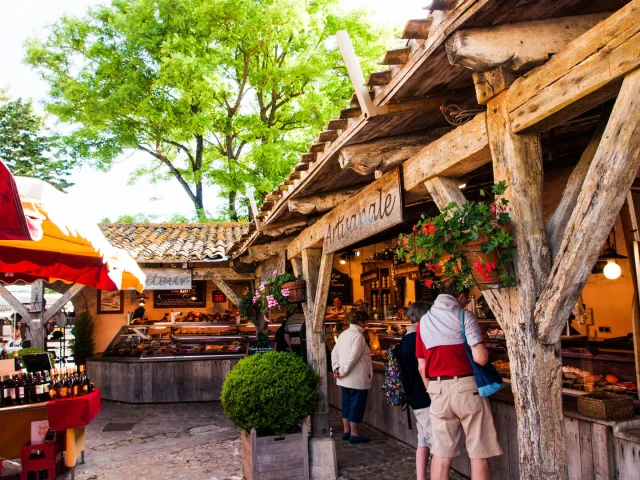 Scène de marché d’inspiration médiévale à La Flotte avec des stands en bois.