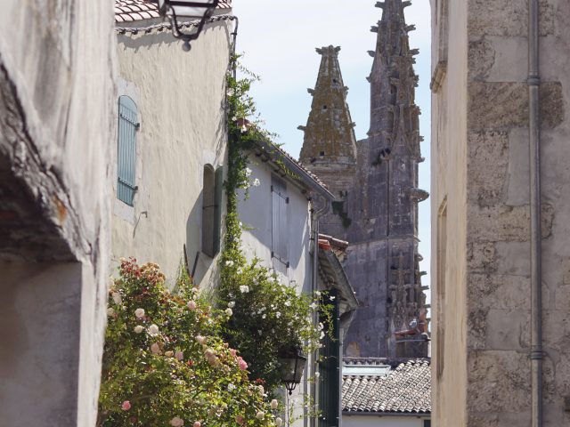 Une petite ruelle de Saint-Martin-de-Ré avec des maisons anciennes et l'église.