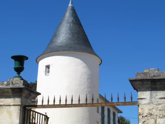 Tour blanche au toit pointu en ardoise vue depuis la rue