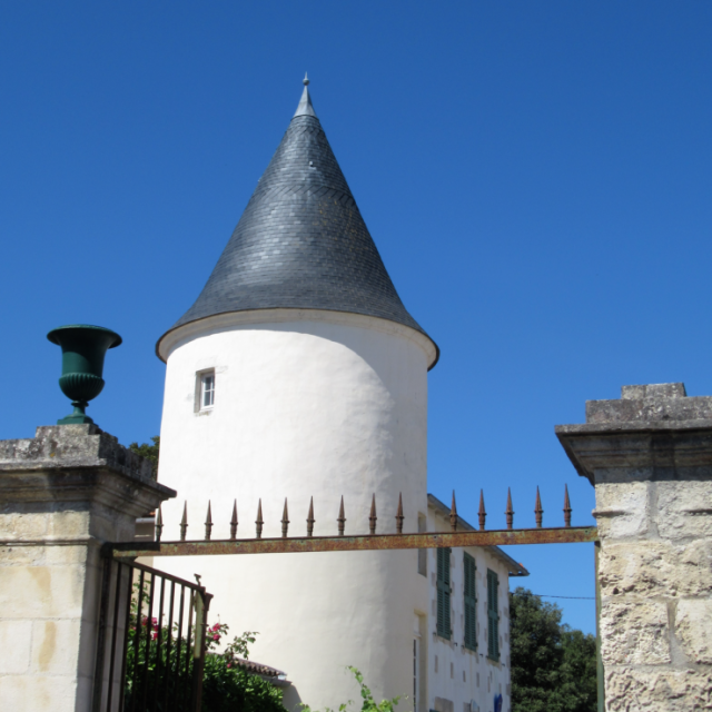 Tour blanche au toit pointu en ardoise vue depuis la rue