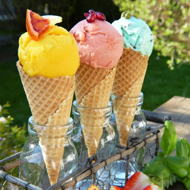 Trois cornets de glace avec des boules de différentes couleurs.