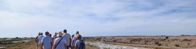 Un groupe de personnes en visite guidée dans les marais salants.