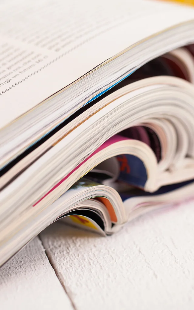 Pile of colorful magazines on a white table