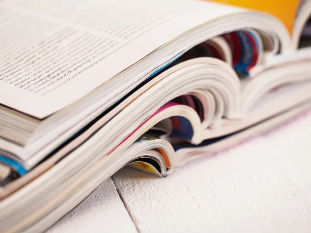 Pile of colorful magazines on a white table