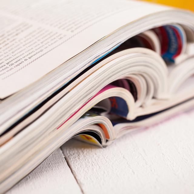 Pile of colorful magazines on a white table