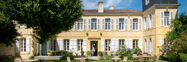 Bâtiment historique de La Baronnie avec jardin bien entretenu