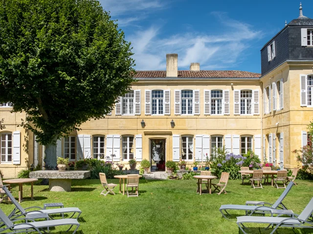 Bâtiment historique de La Baronnie avec jardin bien entretenu