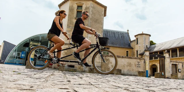 Un couple de cyclistes devant le musée de Saint-Martin