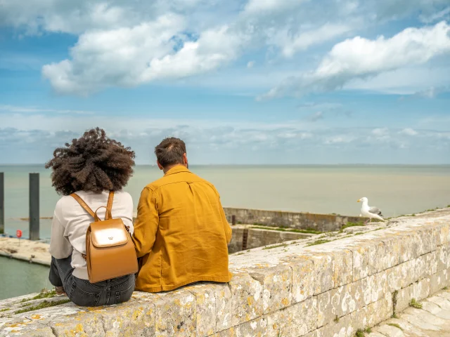 Un couple assis face à la mer au port de Saint-Martin-de-Ré