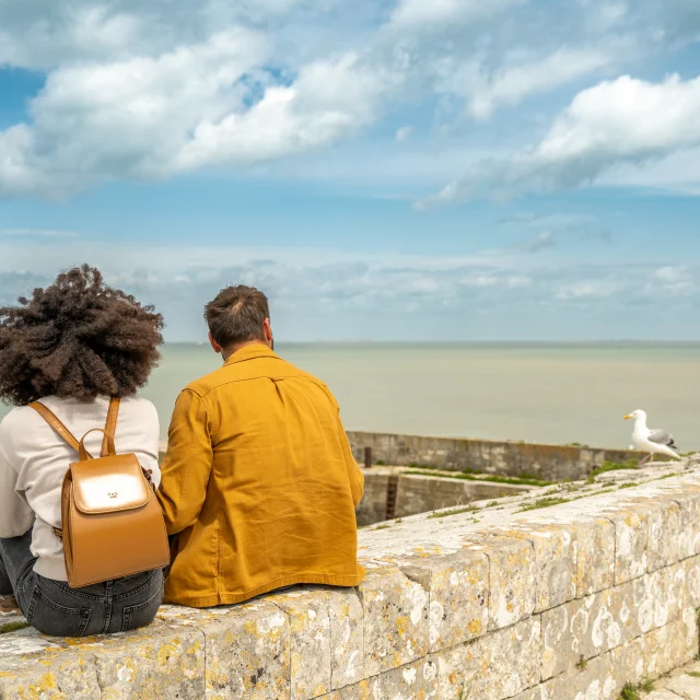 Un couple assis face à la mer au port de Saint-Martin-de-Ré