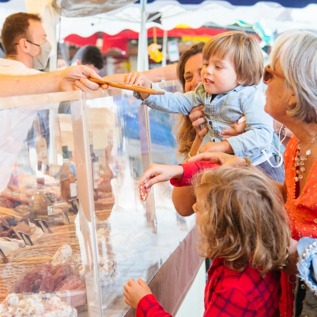 Une famille achète des produits frais au marché de La Flotte.