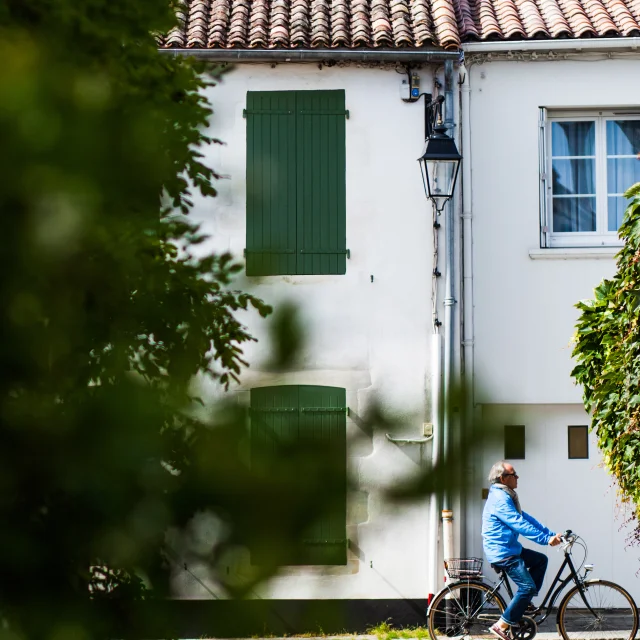 Habitant à vélo dans une venelle typique de l'île de Ré