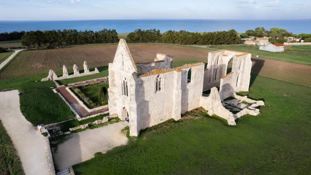 Vue aérienne de l'abbaye des Châteliers à La Flotte avec la mer en arrière-plan.