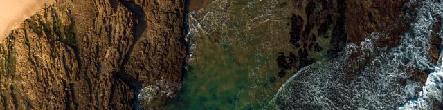 Vue aérienne d'une côte rocheuse avec des vagues.