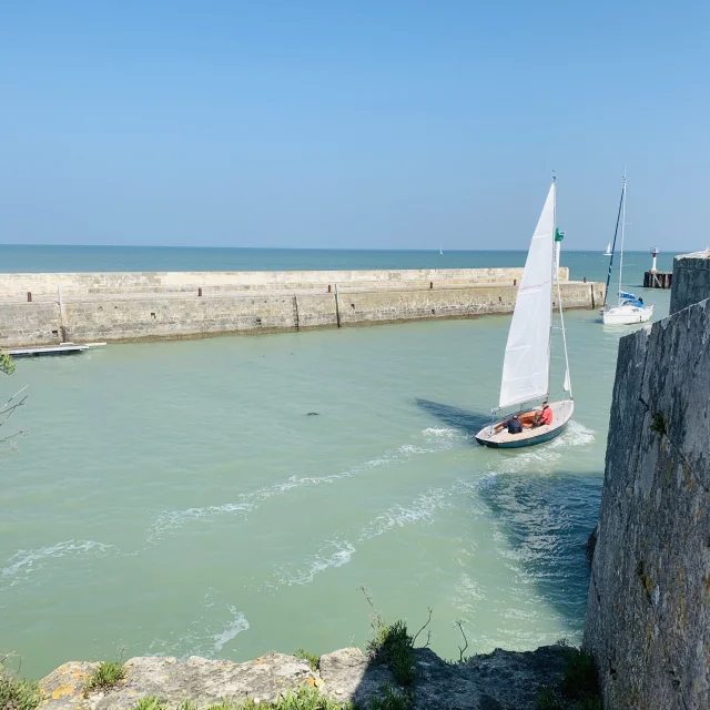 Bateau naviguant vers le port de Saint-Martin-de-Ré sous un ciel bleu