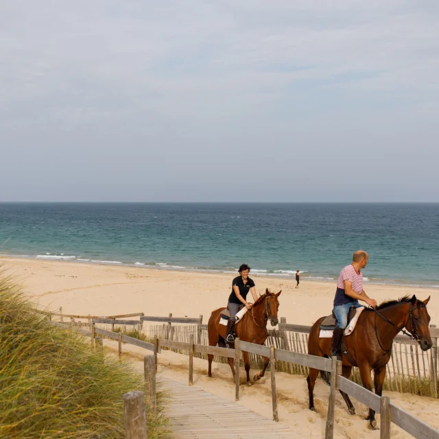 Personnes faisant une balade à cheval sur la plage du Petit Bec