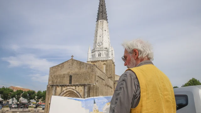 Artiste peignant le clocher d'Ars-en-Ré sur une place publique