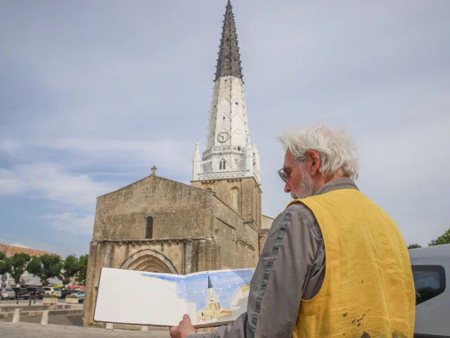 Artiste peignant le clocher d'Ars-en-Ré sur une place publique