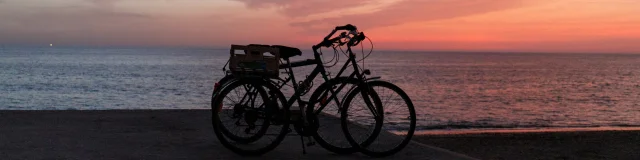 Deux vélos garés face à l'océan au coucher du soleil à Saint-Clément.