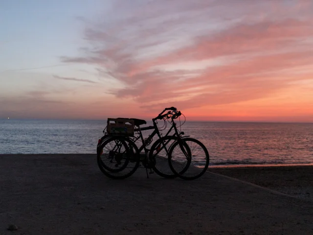 Deux vélos garés face à l'océan au coucher du soleil à Saint-Clément.