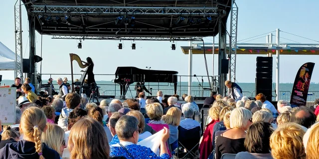 Concert en plein air à Rivedoux avec une foule rassemblée devant une scène.