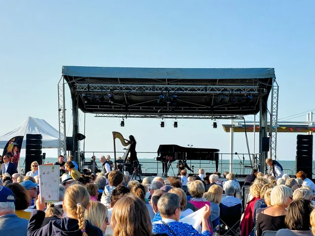 Concert en plein air à Rivedoux avec une foule rassemblée devant une scène.