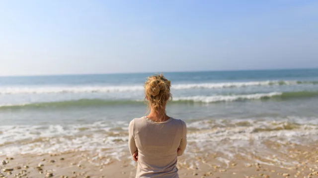 Femme regardant la mer sur la plage des Gollandières.