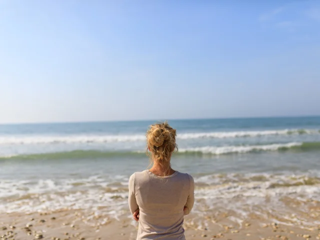 Femme regardant la mer sur la plage des Gollandières.