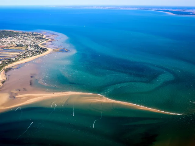 Vue aérienne de l'île de Ré montrant ses plages, eaux turquoise et villages côtiers.