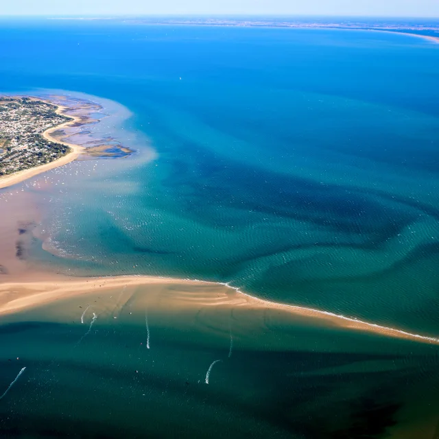 Vue aérienne de l'île de Ré montrant ses plages, eaux turquoise et villages côtiers.