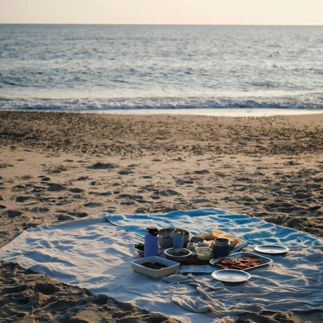 Pique-nique en bord de plage, face au coucher de soleil sur la mer