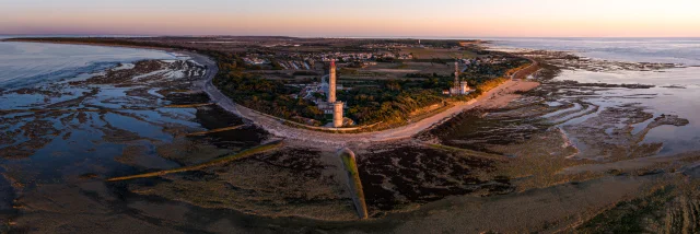 Vue aérienne du phare des Baleines sur la côte avec des marais au coucher du soleil.