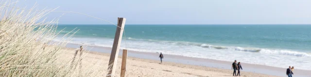 Plage des Gollandières avec des promeneurs.