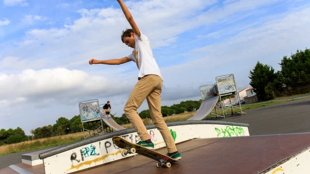 Un adolescent effectuant une figure en skateboard dans un skatepark.