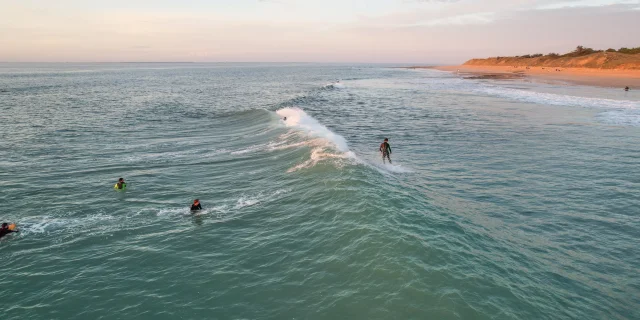 Deux surfeurs dans l'eau, attendant de prendre la prochaine vague au large.