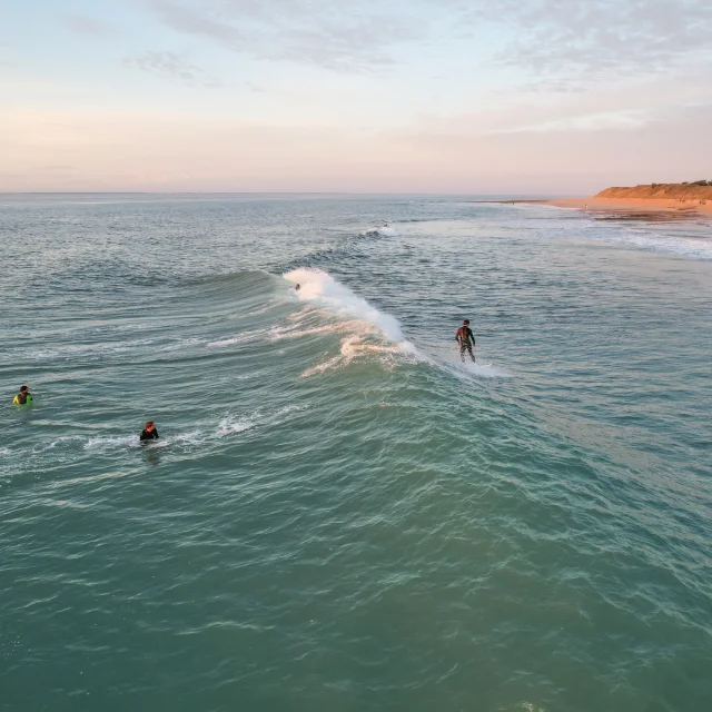 Deux surfeurs dans l'eau, attendant de prendre la prochaine vague au large.