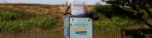 Vélo d'accueil mobile circulant sur un chemin, pour aller informer les visiteurs de passage.