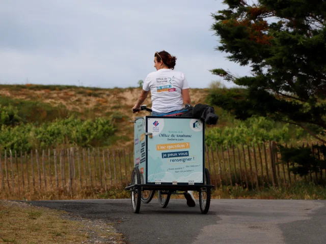 Vélo d'accueil mobile circulant sur un chemin, pour aller informer les visiteurs de passage.