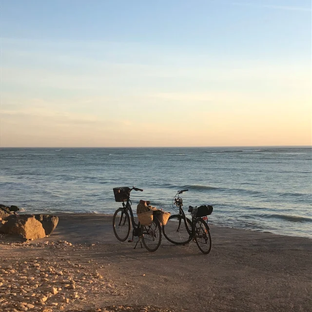 Deux vélos garés sur la plage du Canot de Sauvetage, face à l'océan Atlantique.