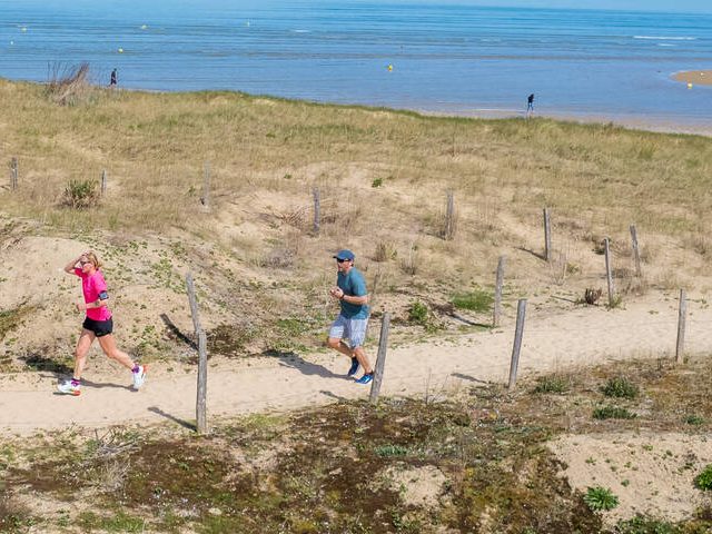 People Running On A Path Near The Beach