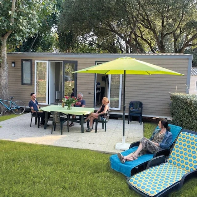 Mobil-home avec terrasse aménagée et chaises longues au Camping Le Puma