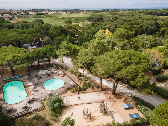 Vue aérienne de la piscine et des installations du camping Huttopia Chardons Bleus