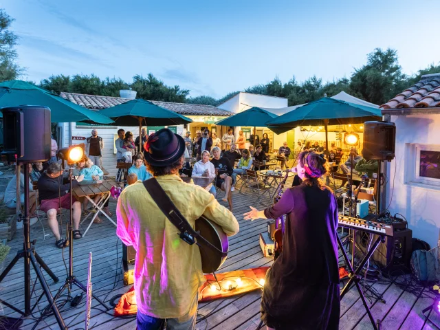 Groupe jouant de la musique en plein air au camping Huttopia Côte Sauvage