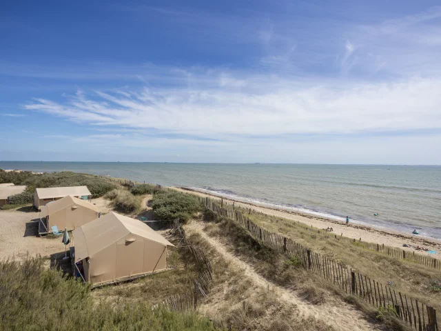 Plage de sable fin avec tentes du camping Huttopia Côte Sauvage