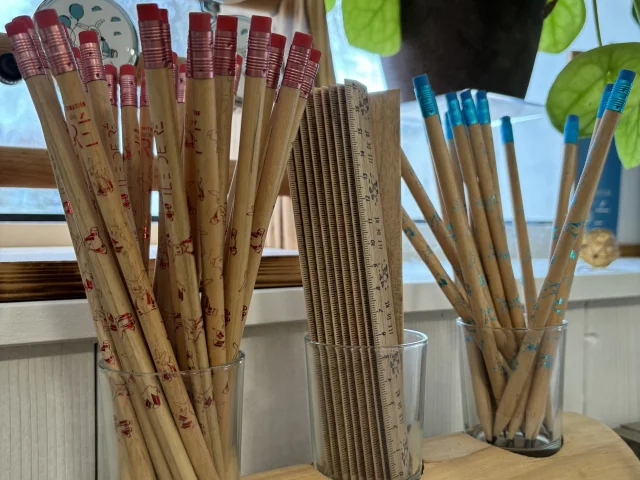 Crayons et règles en bois exposés dans une boutique.