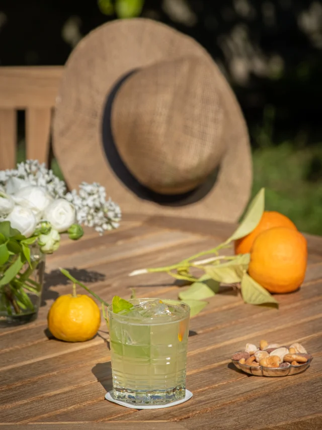 Chapeau posé à côté d'une boisson sur une table en bois