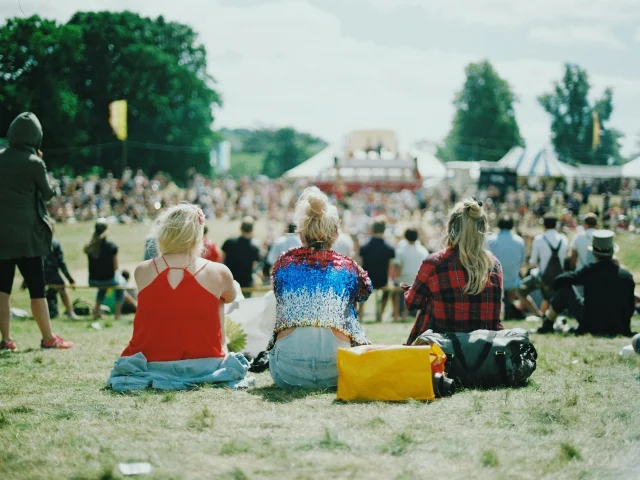 Spectateurs assis sur le sol assistant à une concert